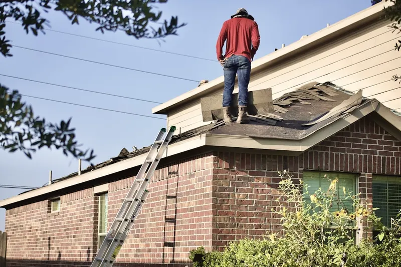 Professional roofer working on a residential roof in West Gate Addition